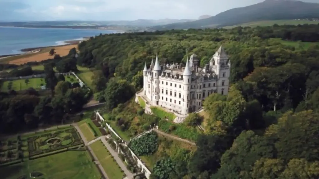 Aerial view of Dunrobin Castle in the Scottish Highlands surrounded by lush gardens and coastline, a popular tourist attraction in Scotland