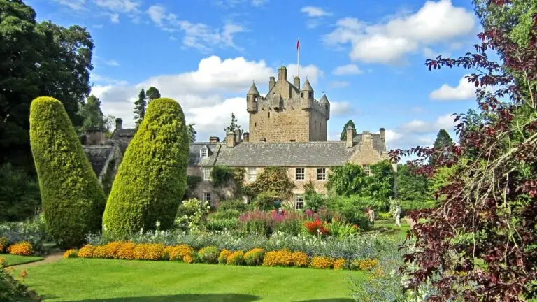 Cawdor Castle in Scotland with vibrant gardens on a sunny day, featured on a 10 day private tour with Braw Scottish Tours