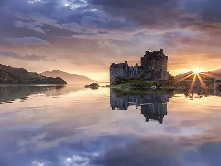Eilean Donan Castle at sunset reflecting on the water, iconic Scottish Highlands tourist attraction in Scotland