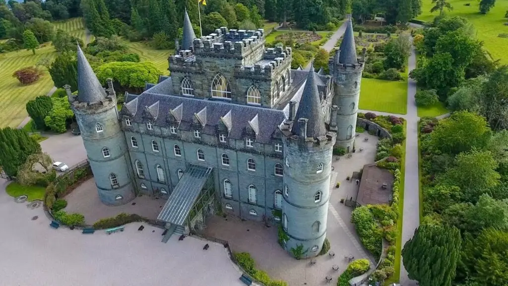 Aerial view of Inveraray Castle surrounded by lush gardens in Argyll, Scotland, a popular tourist attraction and historic landmark