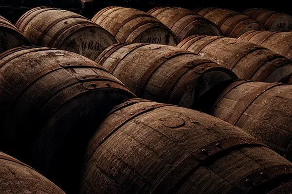 Aging whisky barrels in a traditional Speyside distillery, Scotland, showcasing sherry oak casks used in Scotch whisky production