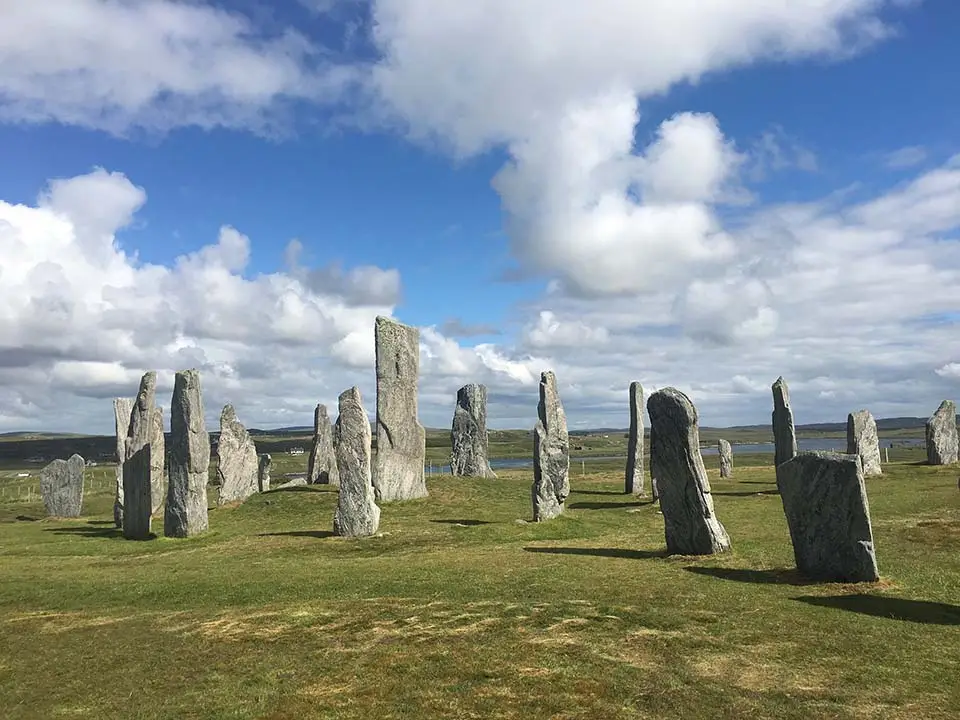 Callanish Standing Stones in Scotland, ancient stone circle on the Isle of Lewis under a partly cloudy blue sky, popular Scottish tourist attraction and historic site