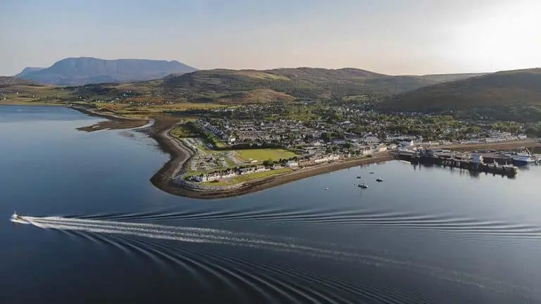Aerial view of Ullapool coastline and harbor surrounded by hills in the Scottish Highlands, Scotland tourism destination