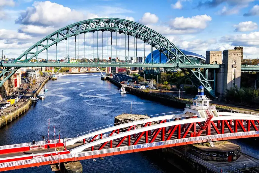 View of the iconic Tyne Bridge and Swing Bridge over the River Tyne in Newcastle, England, showcasing the city’s waterfront architecture and popular tourist attractions.