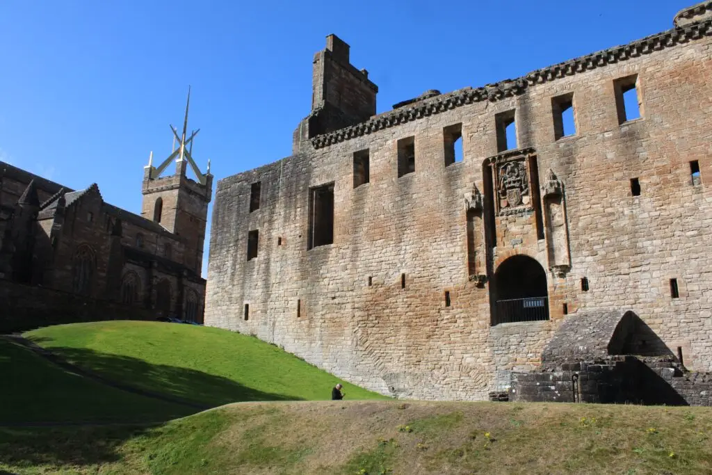 Historic Linlithgow Palace in Scotland with medieval stone walls and towers under a clear blue sky, a popular Scottish heritage and tourism attraction