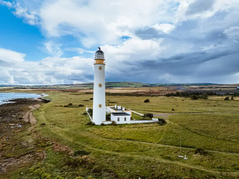 Barns Ness Lighthouse on the East Lothian coastline in Scotland with dramatic clouds and coastal landscape, popular tourist attraction near Dunbar