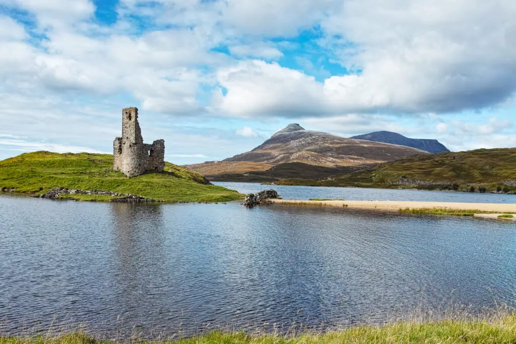 Ardvreck Castle ruins on Loch Assynt in the Scottish Highlands surrounded by mountains and scenic landscapes, popular historic site in Scotland