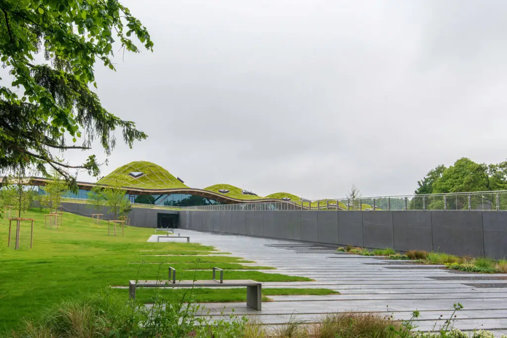 Modern architecture of Macallan Whisky Distillery with grass-covered roof surrounded by green landscape in Speyside, Scotland
