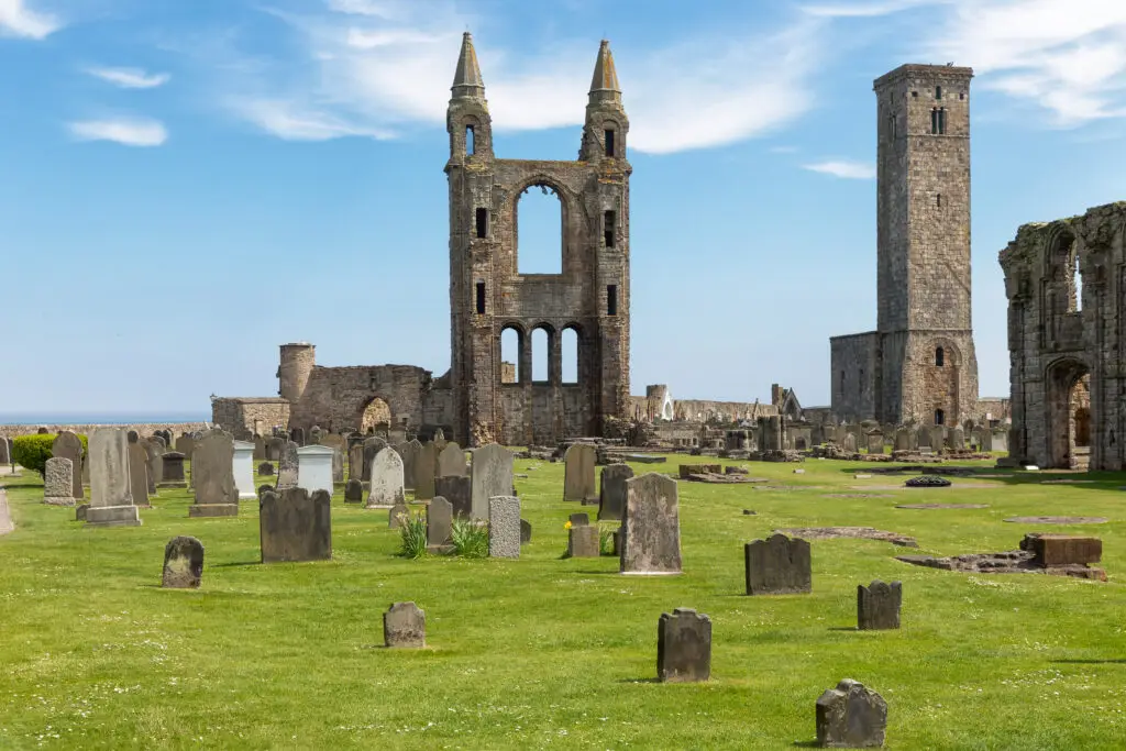 Ruins of St Andrews Cathedral with historic graveyard under blue sky in St Andrews, Scotland