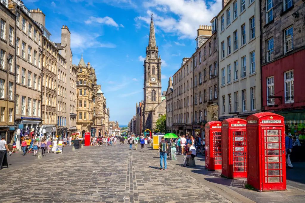 Royal Mile in Edinburgh Scotland featuring historic architecture cobbled streets red telephone boxes and tourists exploring the famous attraction
