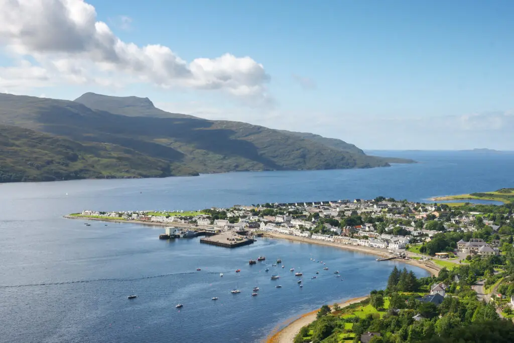 Scenic view of Ullapool village by Loch Broom with boats in the harbour and surrounding mountains in the Scottish Highlands, Scotland