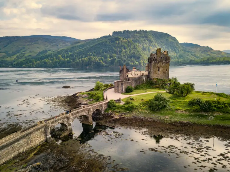 Eilean Donan Castle in the Scottish Highlands surrounded by water and mountains, a popular tourist attraction in Scotland