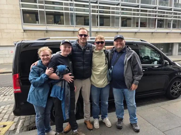 The Hirschi family with their Braw Scottish Tours driver-guide beside their private vehicle during a family tour of Scotland.